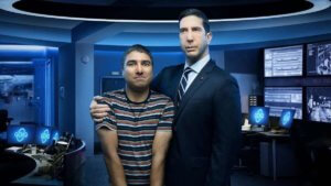 A tall suited man embracing a short nerd in a high-tech lab