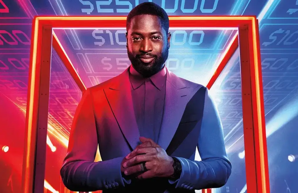 A black man in a blue suit in front of a glowing red cube frame.