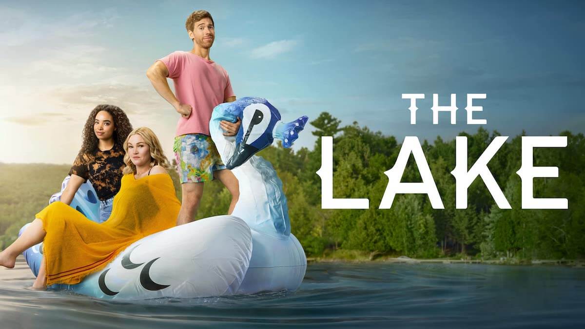 Three people sitting on a large inflatable swan on. a lake.