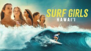 A lineup of four women surfers shown over a surfer riding a big wave