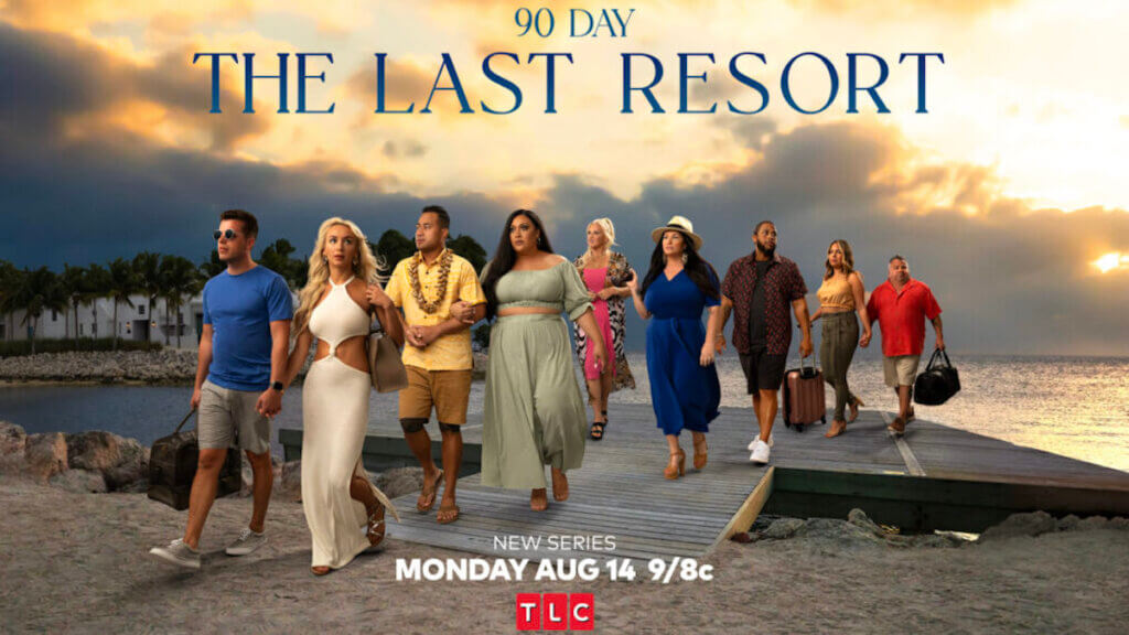 A group of couples walk onto a beach from a gang plank