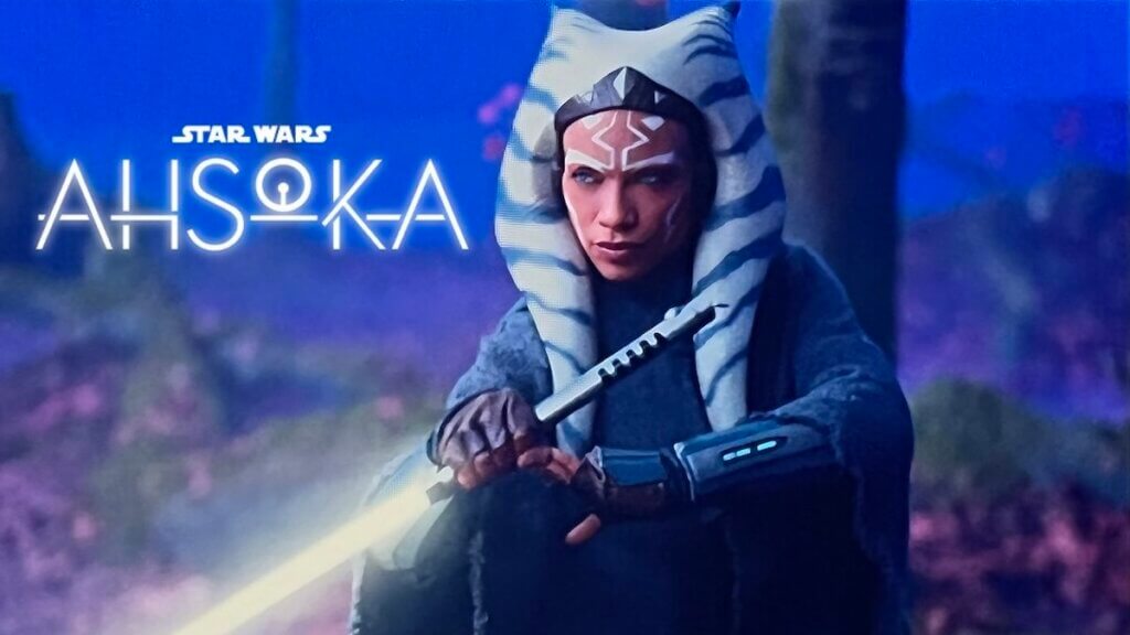A science fiction character with blue and white striped headpiece and a lightsaber on a grey and blue planet