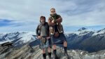 Two men in kilts on a snowy mountaintop.