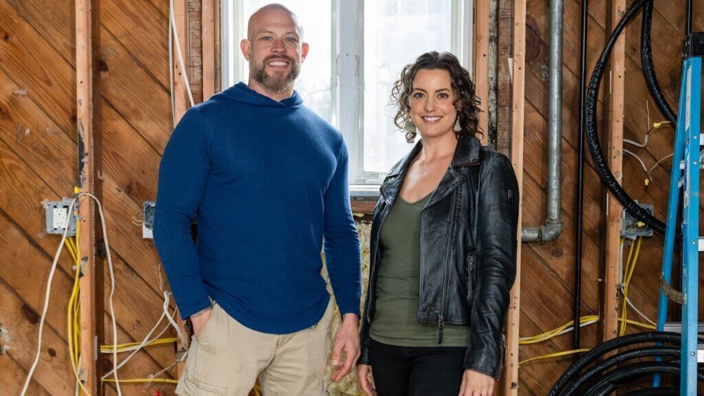 An inspector and designer stand together in striped down home remodel space