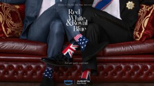 Lower half of two men sitting on a leather couch in nice suits, with their crossed legs crossing each other's at the ankles, showing of socks with flags of US and UK on them