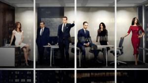 A group of six polished legal professionals around a conference table behind large glass windows