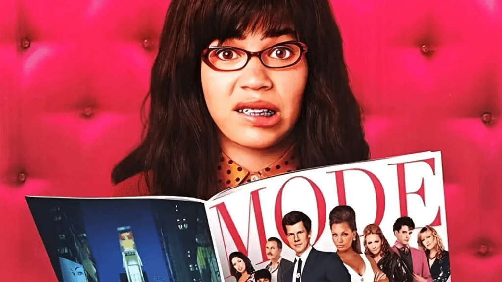 An awkward woman in glasses and braces makes a face over a magazine with a glamorous group of people on the cover.